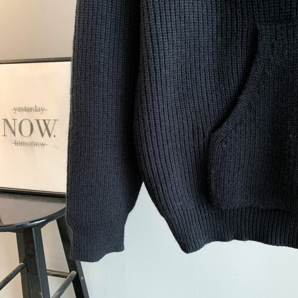 Dark hooded knit sweater side view with ribbed hem and textured knit pattern