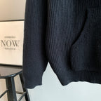 Dark hooded knit sweater side view with ribbed hem and textured knit pattern