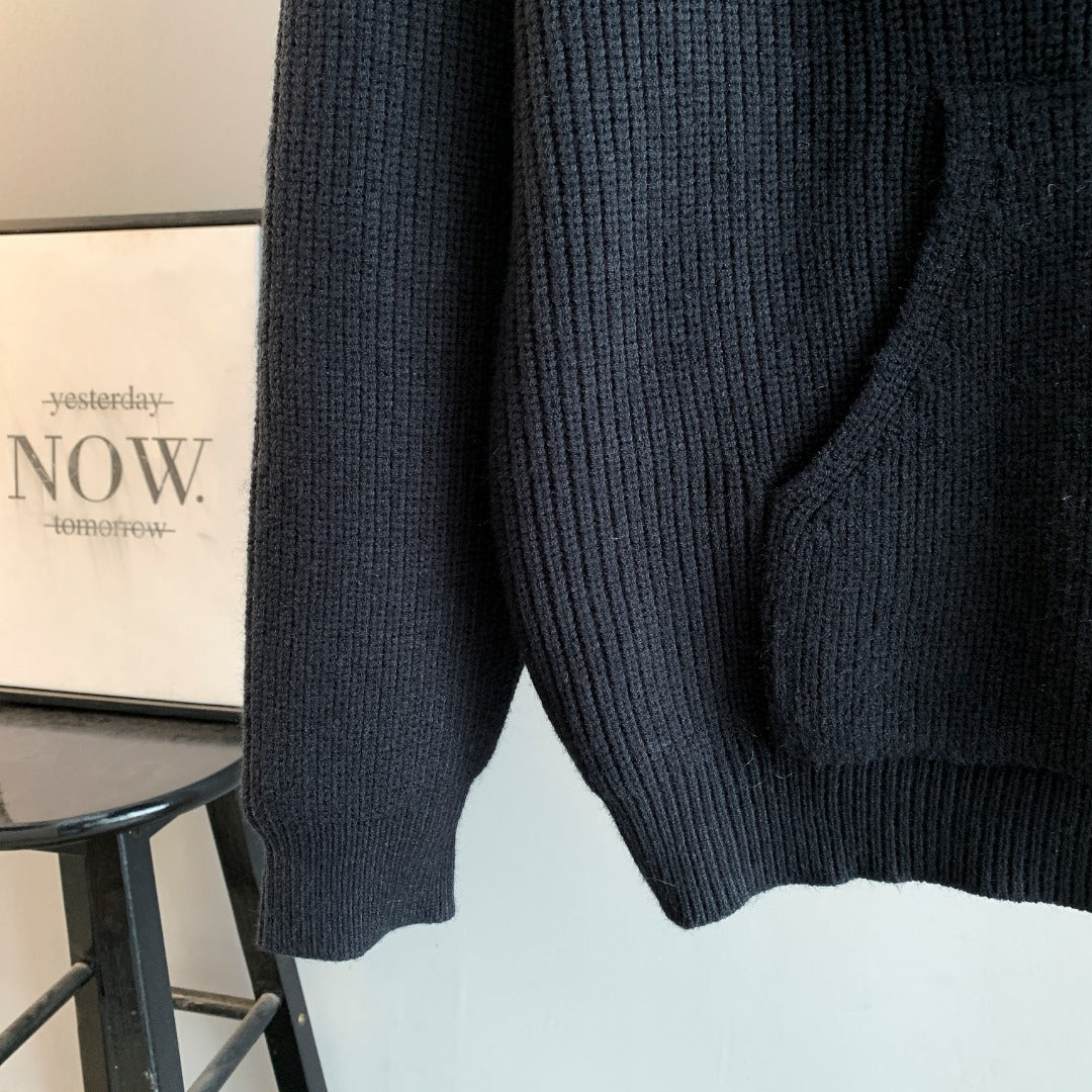 Dark hooded knit sweater side view with ribbed hem and textured knit pattern