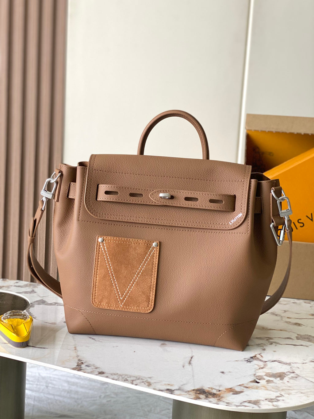 Louis Vuitton tan leather tote bag with top handles, front flap, and metal logo detail