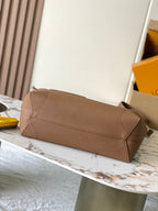 Louis Vuitton tan leather clutch-style bag with long strap and flap closure