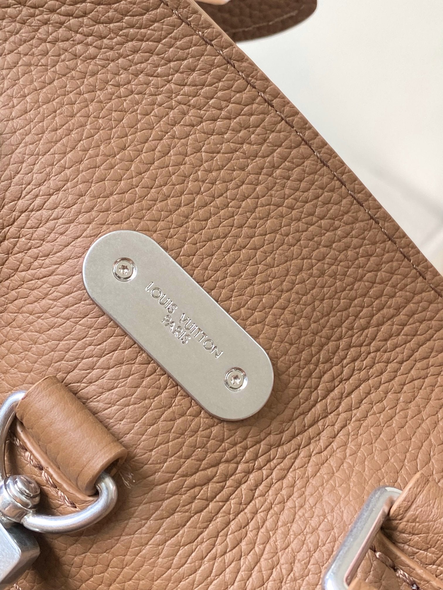 Louis Vuitton tan leather side with oval metal logo tag and top ring hardware