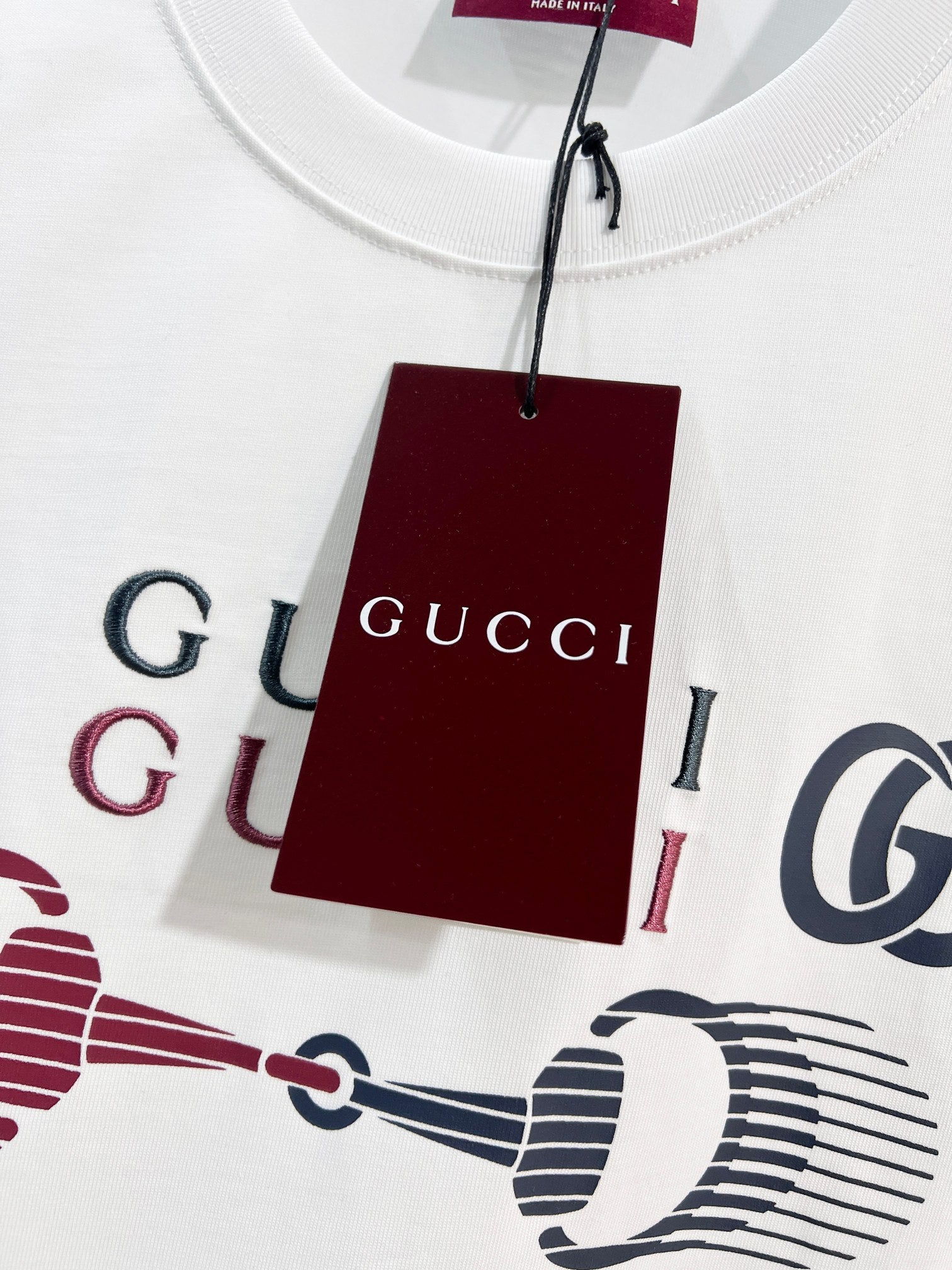 White Gucci T-shirt with large logo print and attached red branded tag