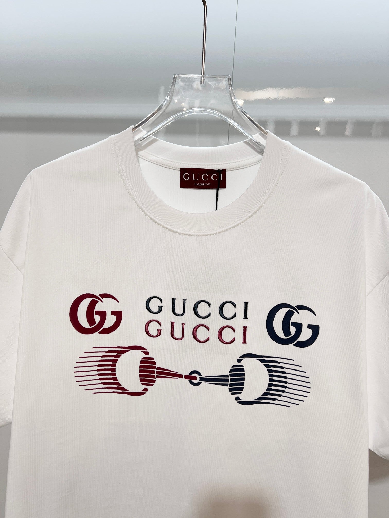 White Gucci crewneck T-shirt with front graphic Gucci logo, close-up
