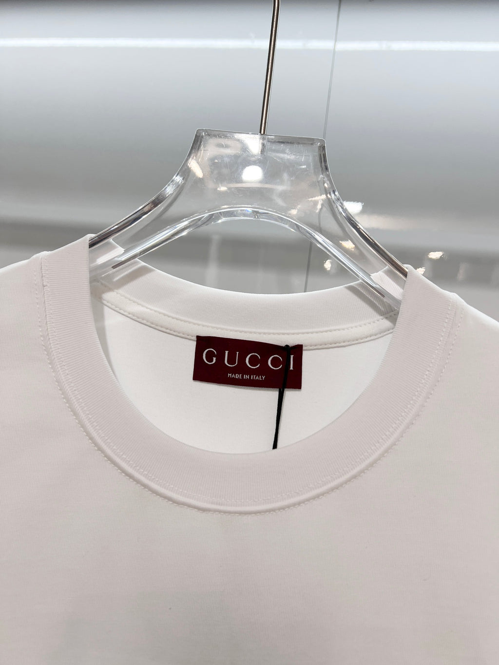 White Gucci crewneck T-shirt with neckline tag, front view close-up