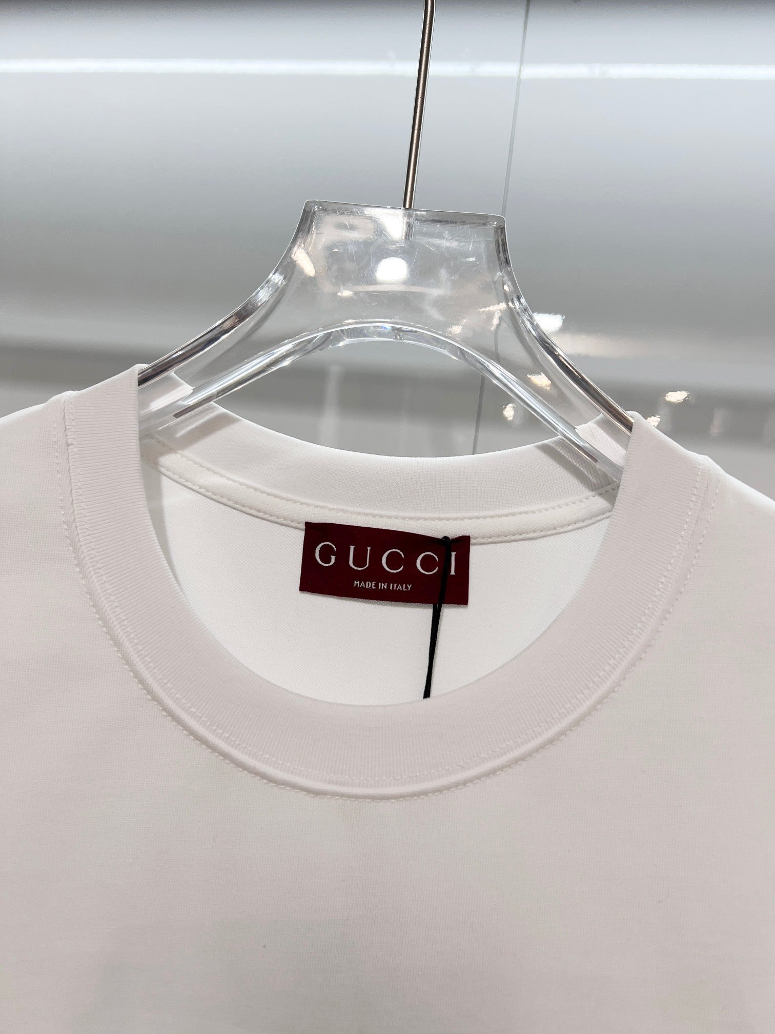 White Gucci crewneck T-shirt with neckline tag, front view close-up