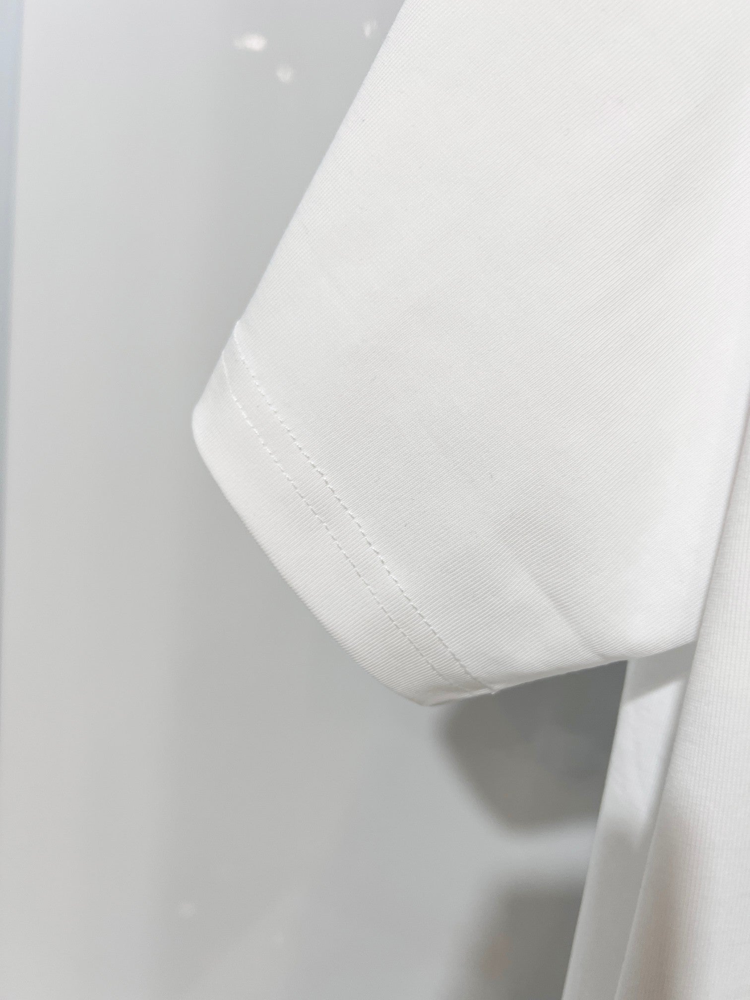 White Gucci T-shirt hem and side seam detail, close-up