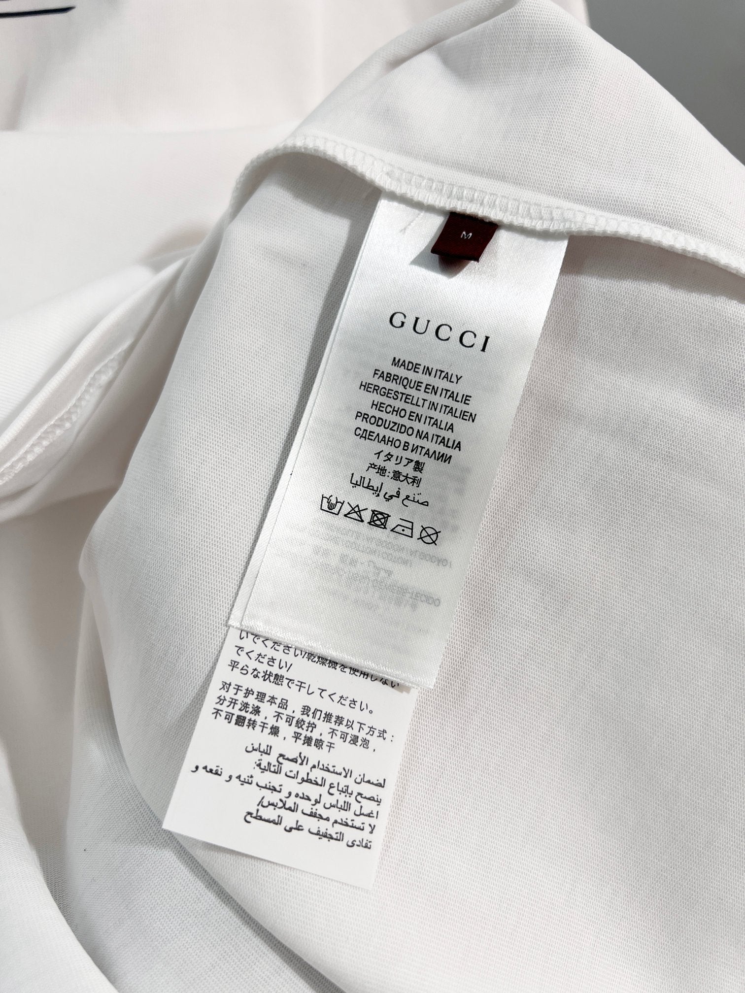 Gucci T-shirt inside neck label and care tag, close-up