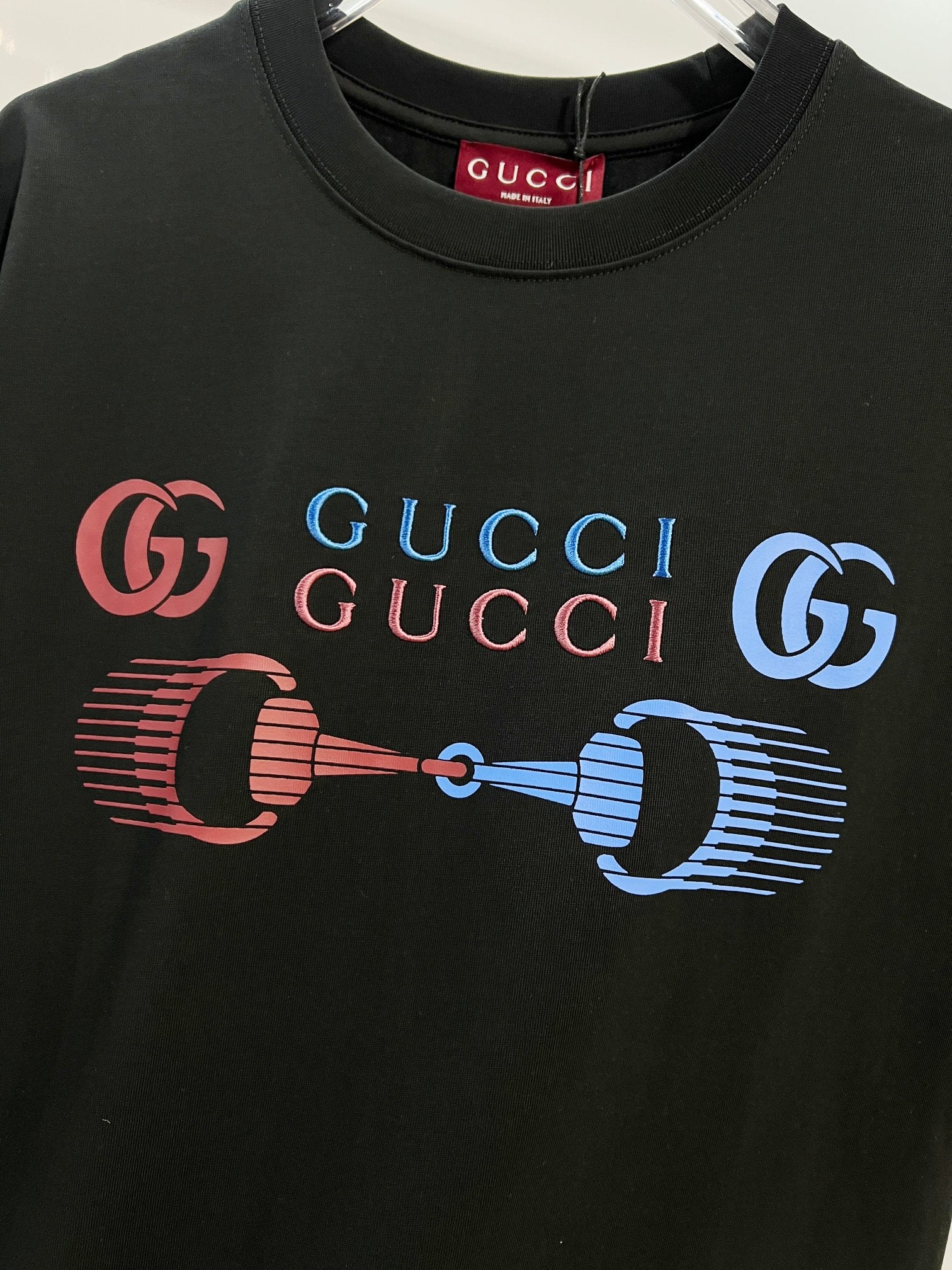 Black Gucci T-shirt front close-up showing GG and colorful horse-bit graphic