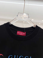 Black Gucci T-shirt close-up of crew neck with red Gucci brand tag