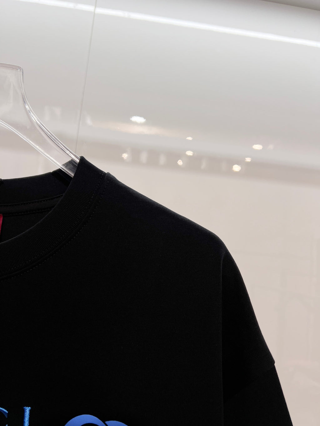 Black Gucci T-shirt side view with hanging tag, short sleeves and crew neck
