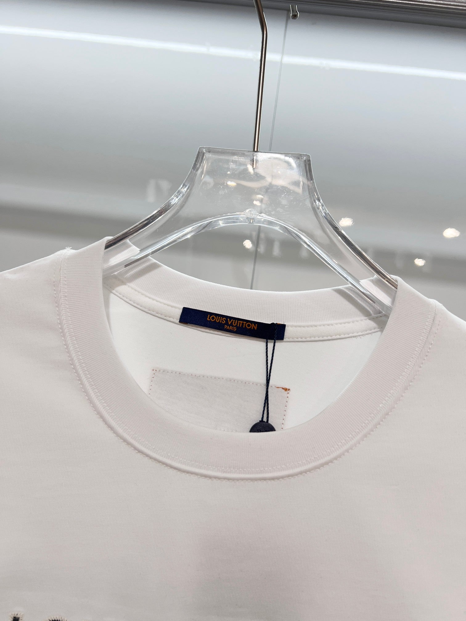 White T-shirt neckline close-up with inner brand label on hanger