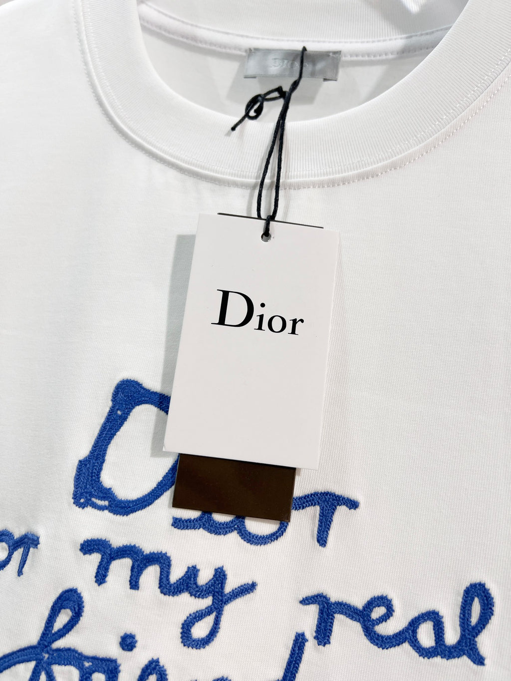 White Dior short-sleeve T-shirt neckline with attached Dior hang tag