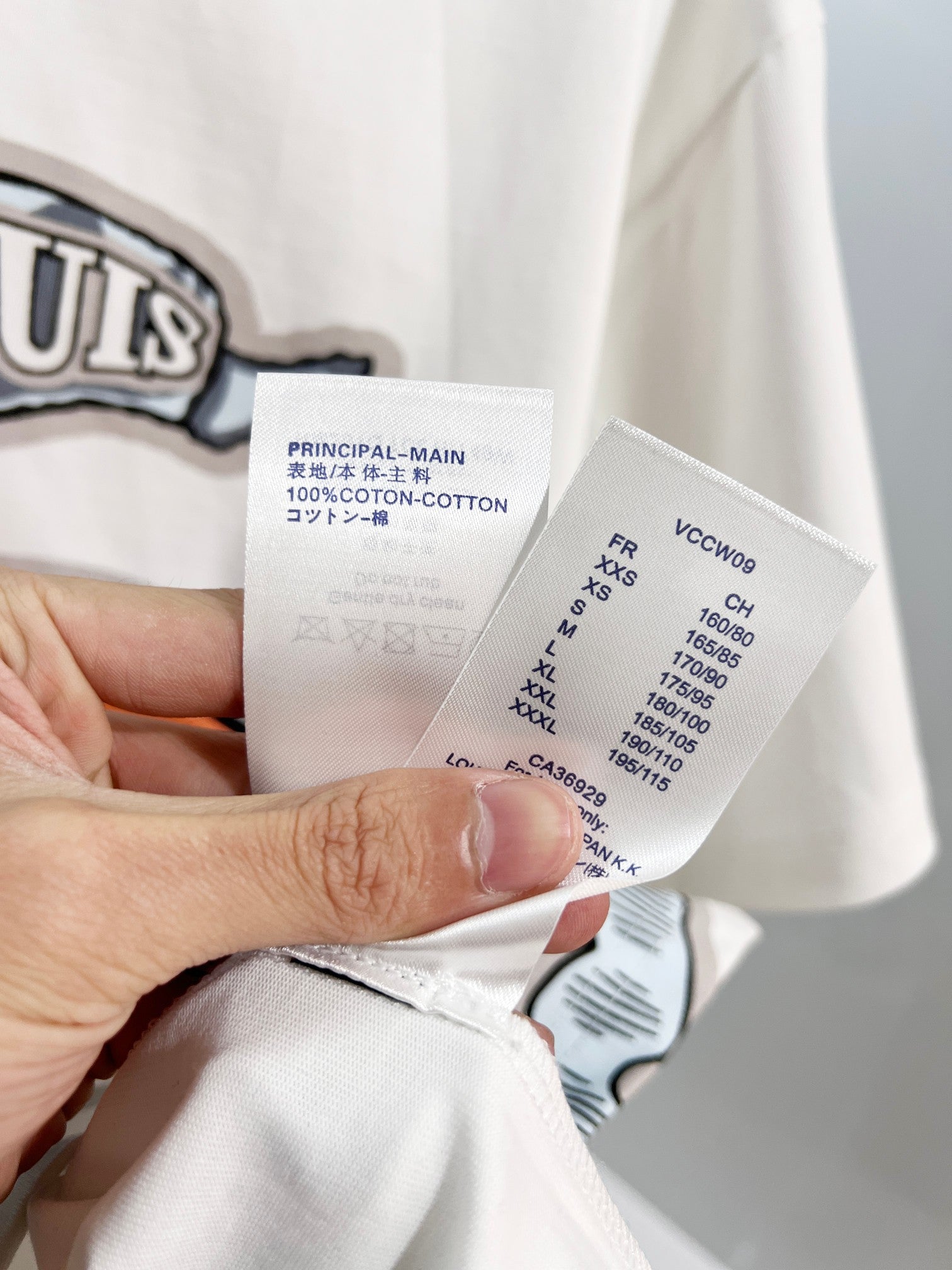 White Louis Vuitton T-shirt care label showing 100% cotton and size info