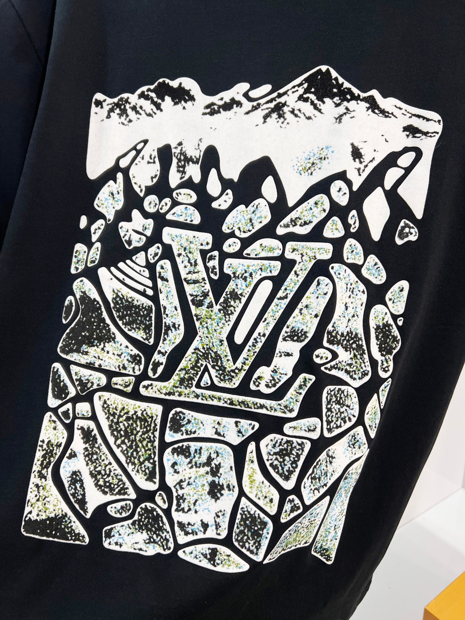 Louis Vuitton black T-shirt close-up of the front white and glittery logo graphic