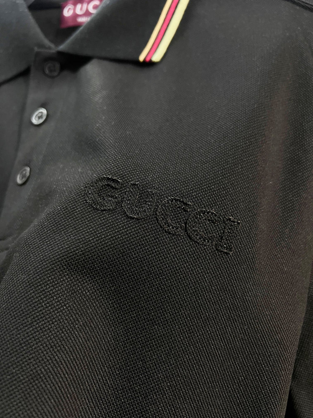 Gucci black polo shirt fabric texture with embroidered logo near chest
