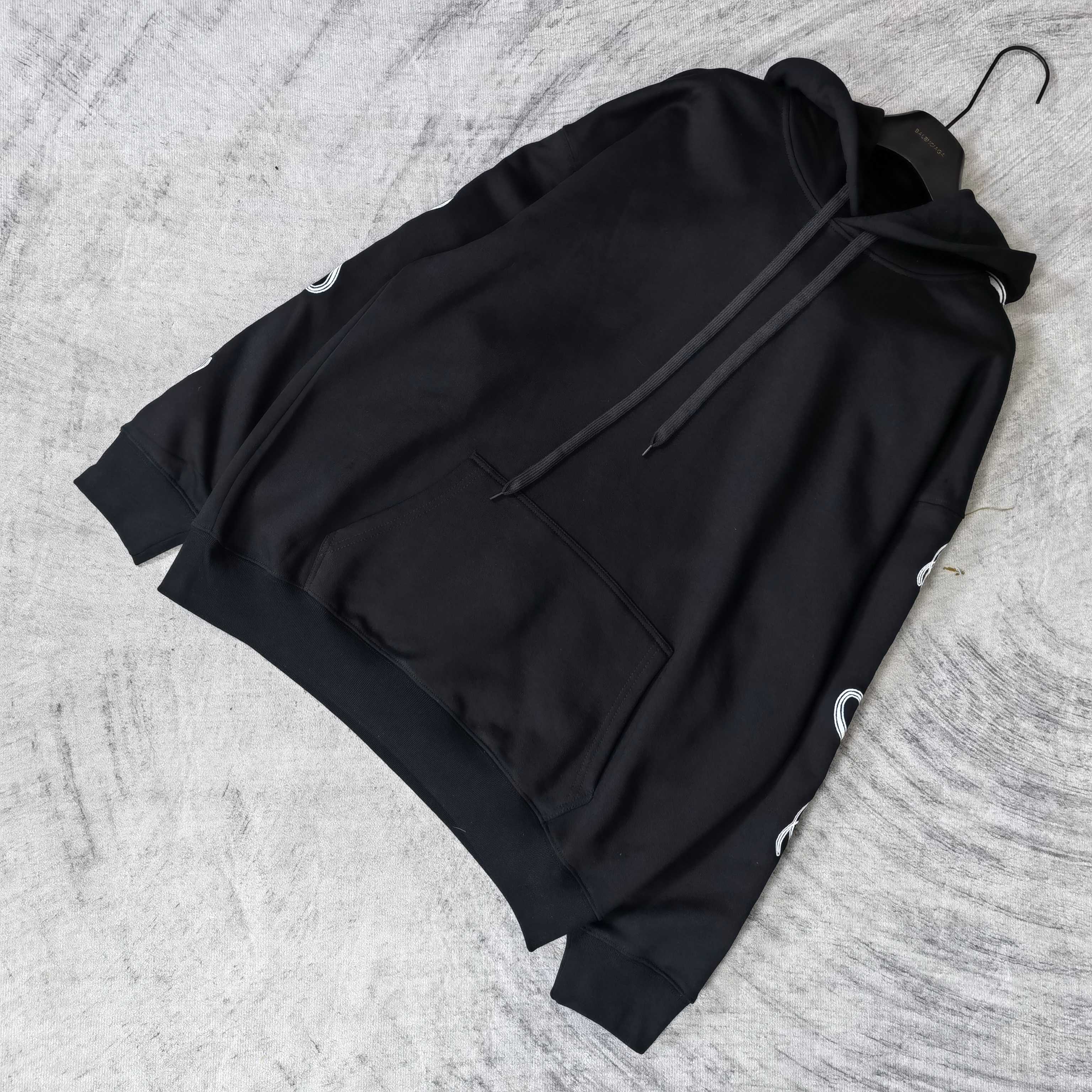 Balenciaga black hoodie laid flat with hood, drawstring, and front pocket