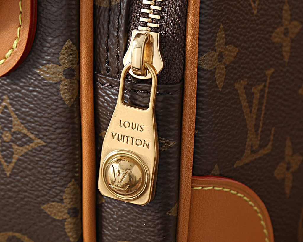 Louis Vuitton bag clasp and zipper pull with engraved logo on brown canvas