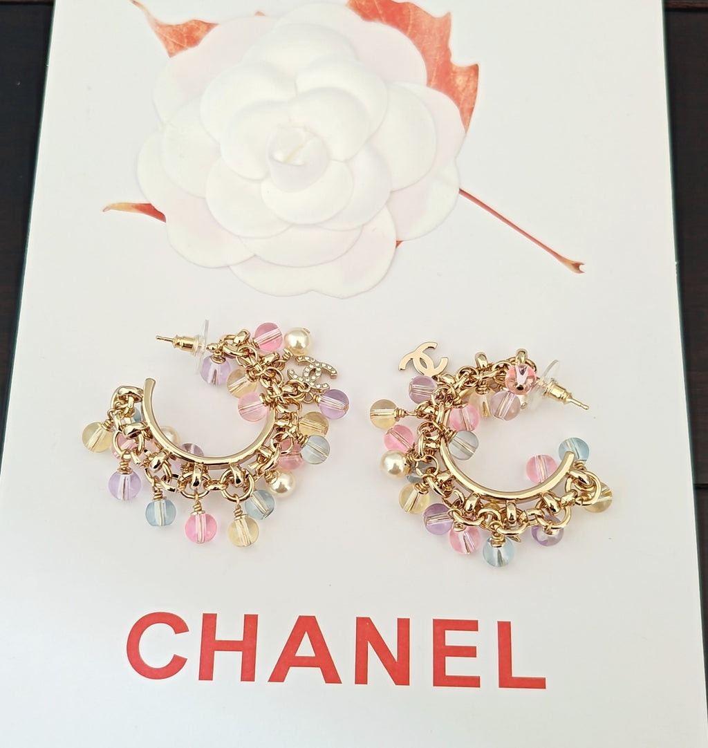 Gold-tone beaded hoop earrings with pink, lilac, blue, and pearl charms