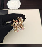 Gold-tone beaded hoop earrings with pink, blue, and clear crystals
