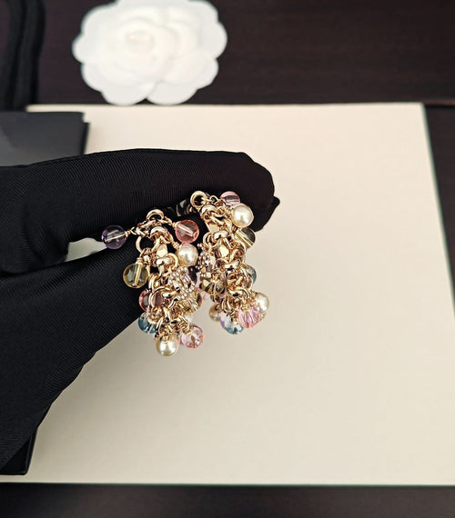 Gold-tone beaded hoop earrings with pink, blue, and clear crystals