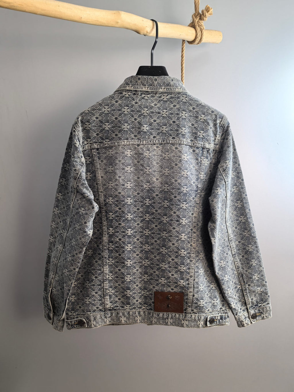 Back view of gray long-sleeve jacket with embroidered floral pattern and button closure