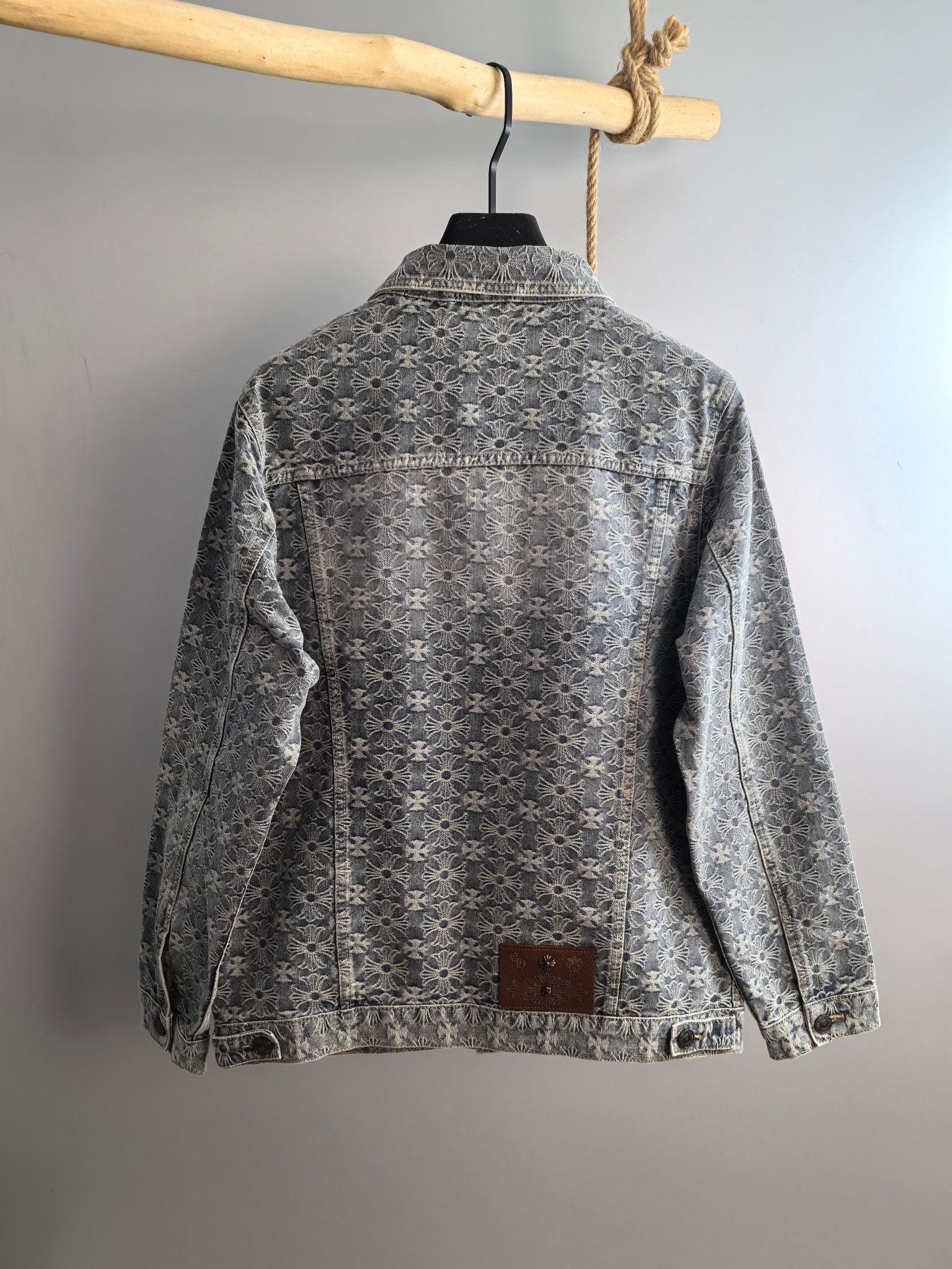 Back view of gray long-sleeve jacket with embroidered floral pattern and button closure