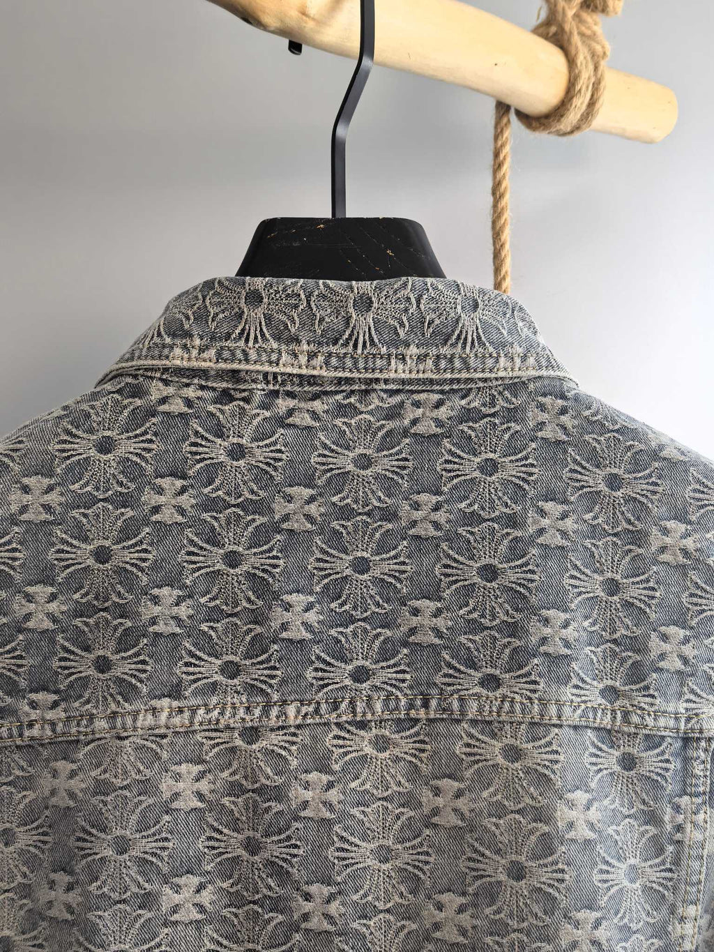 Upper back of gray jacket with embroidered floral pattern and yoke stitching