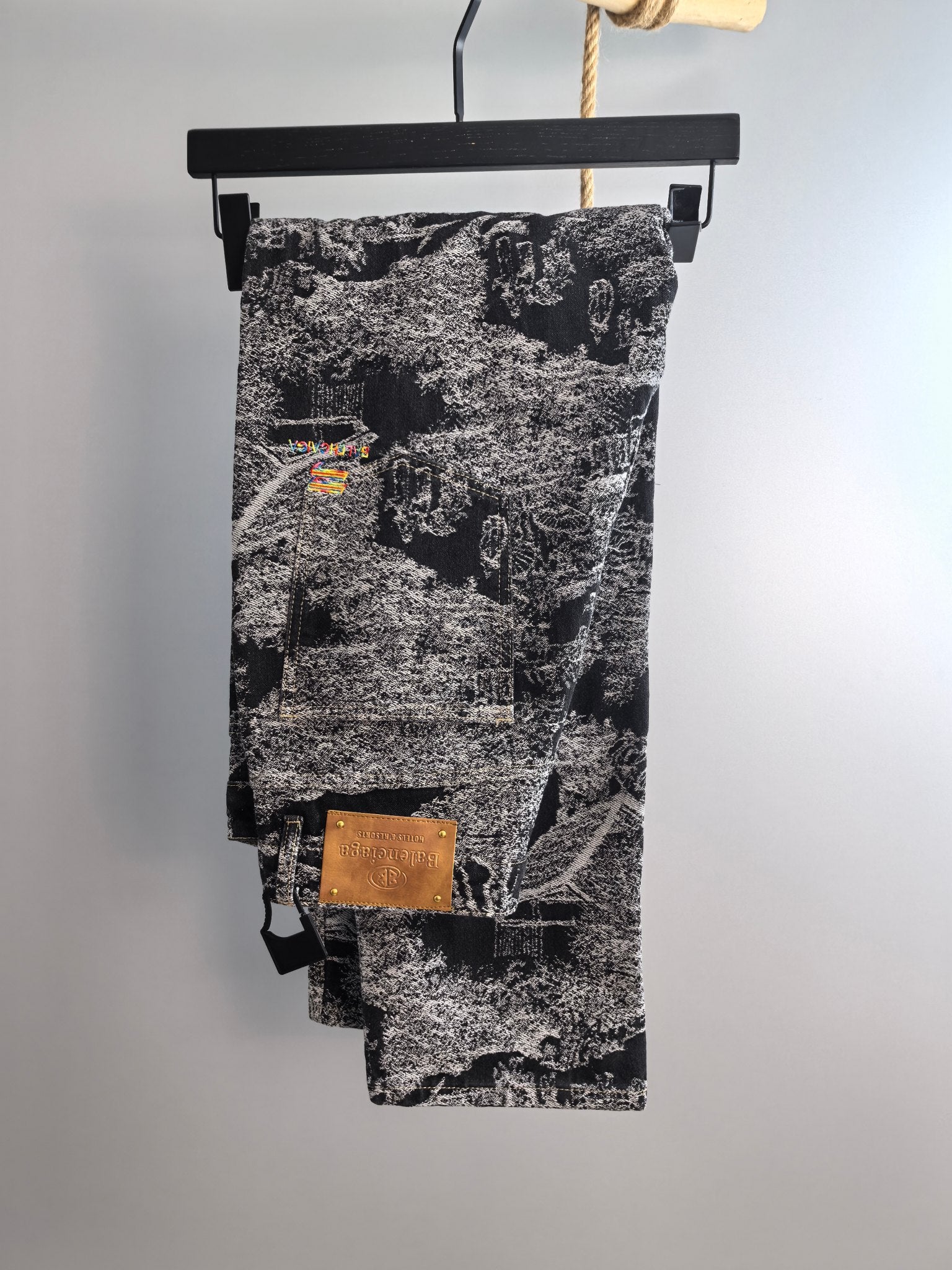 Black-and-white abstract printed long pants, draped on a hanger