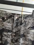 Close-up of black-and-white abstract printed pants waistband with metal button details