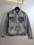 Denim jacket with pointed collar and chest logo patches, light blue wash