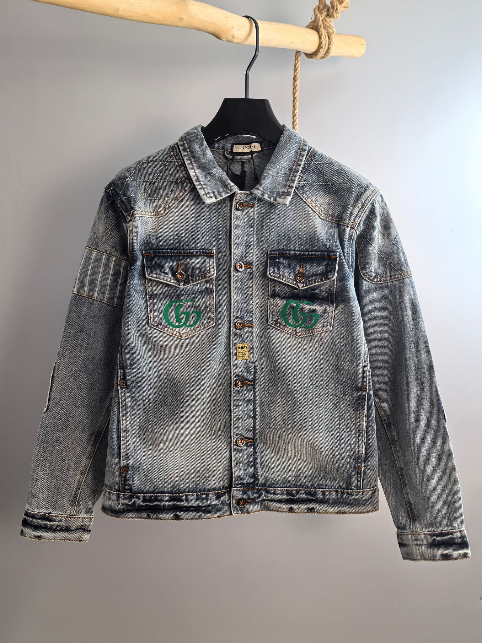 Denim jacket with pointed collar and chest logo patches, light blue wash
