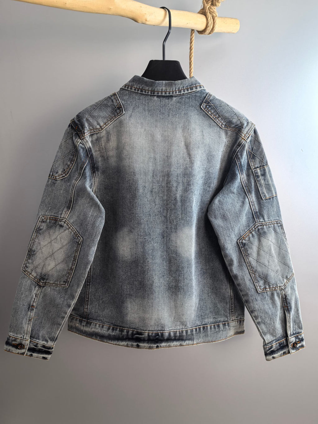 Denim jacket back view with curved yoke seam, light blue wash