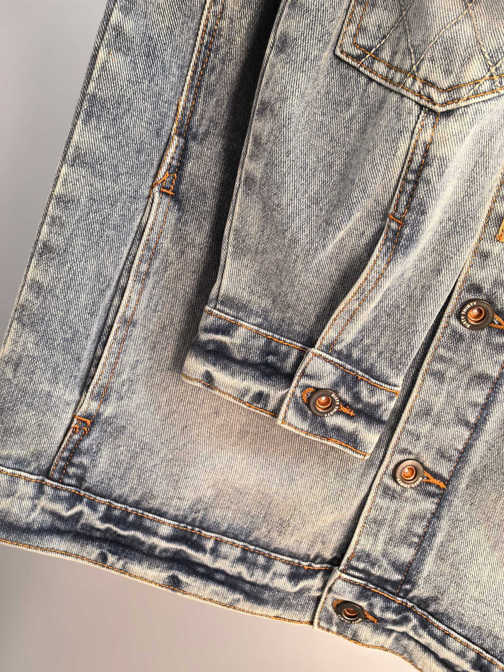 Denim jacket front lower hem with two pockets and copper button details