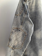 Denim jacket side with quilted patch pocket and stitched seam, light blue wash
