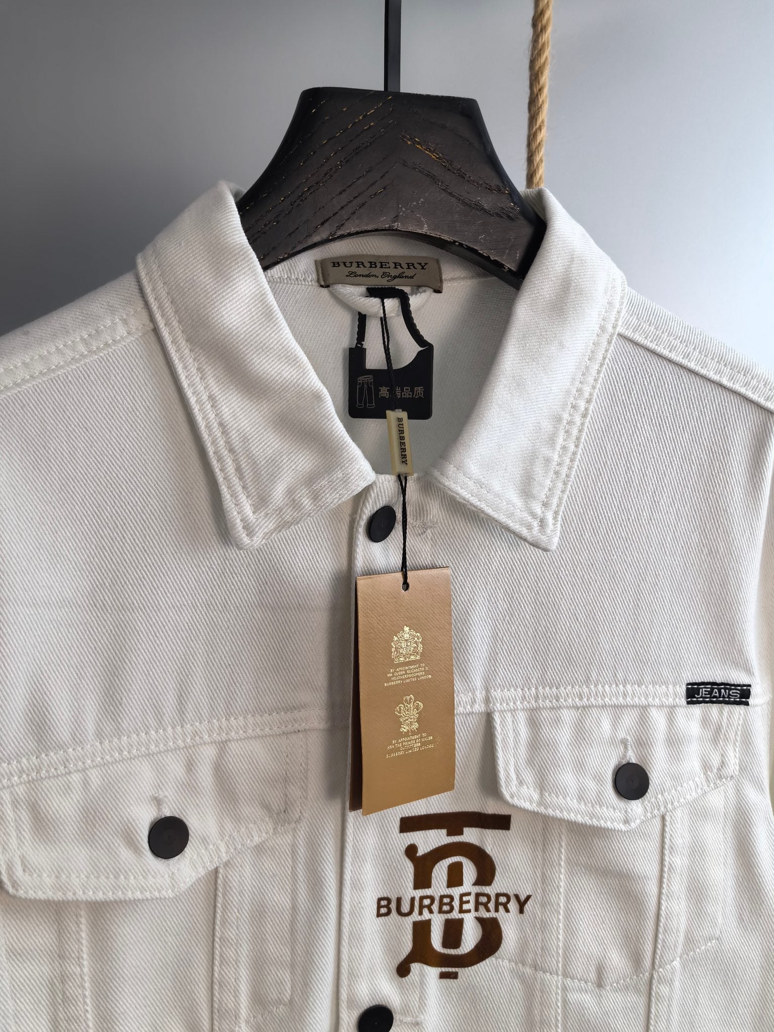 Burberry long-sleeve jacket in white with front emblem, button placket, and flap chest pockets
