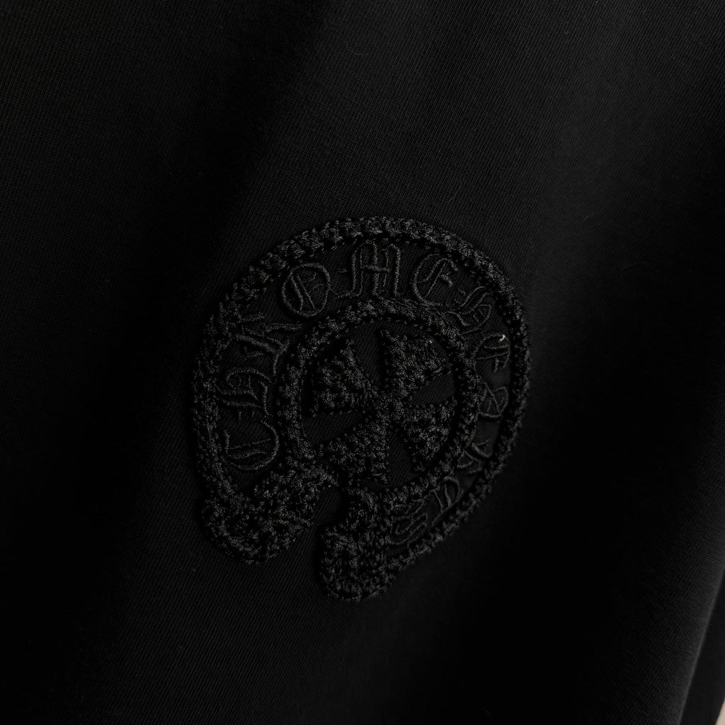 Black short-sleeve T-shirt with embossed circular crest logo