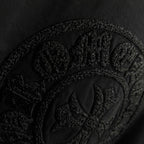 Black short-sleeve T-shirt with embossed circular crest logo detail
