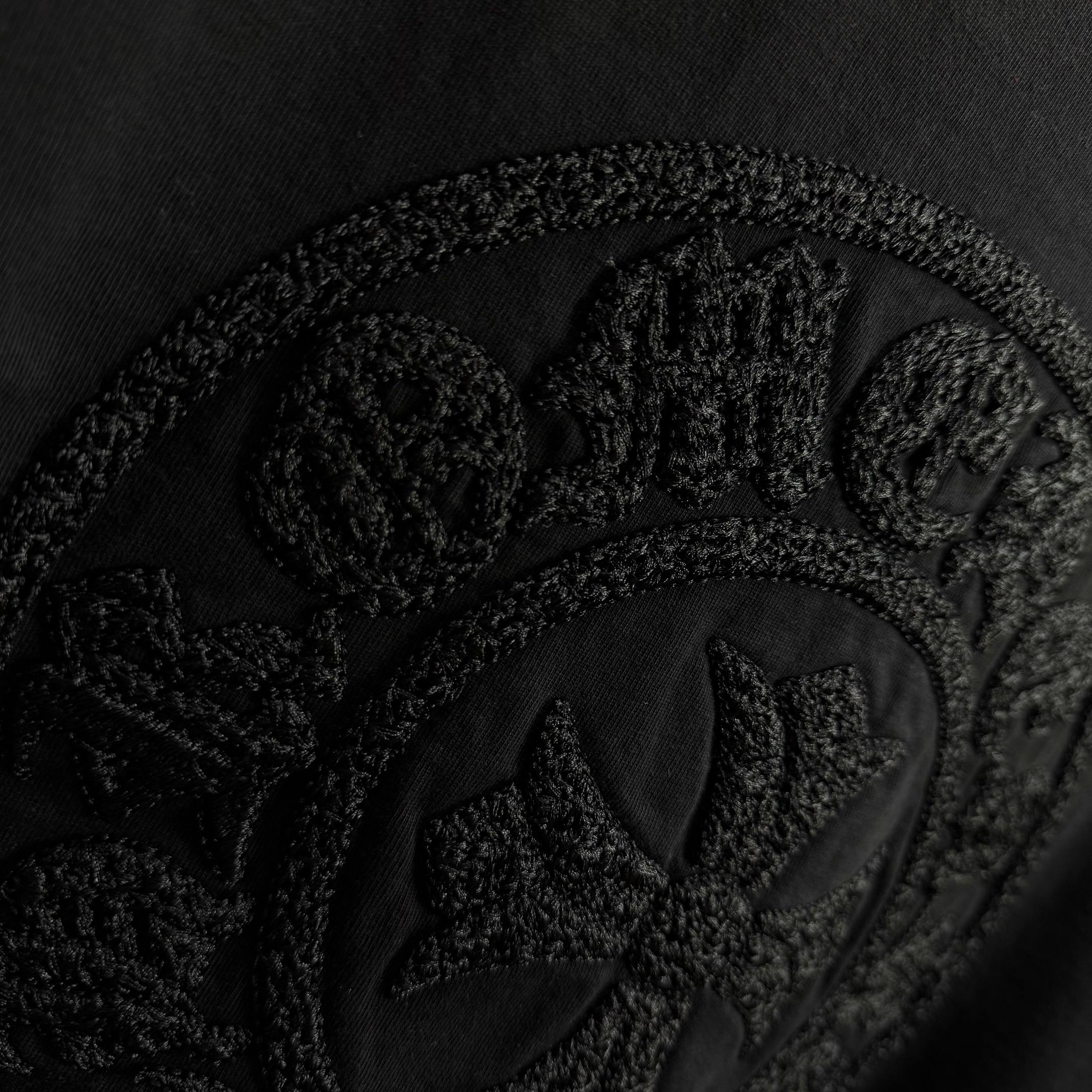 Black short-sleeve T-shirt with embossed circular crest logo detail