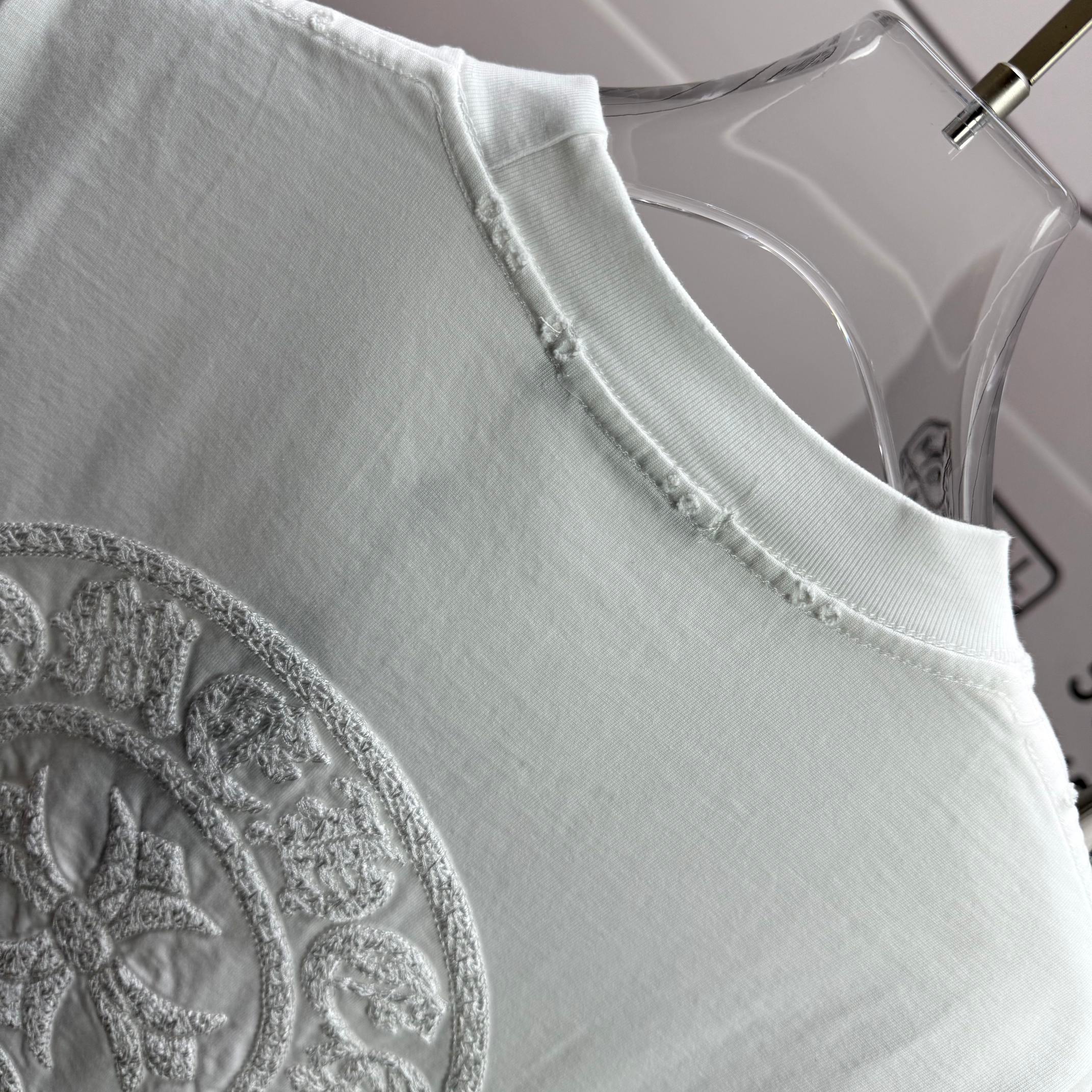 Light T-shirt neckline with partial circular embroidered crest logo.