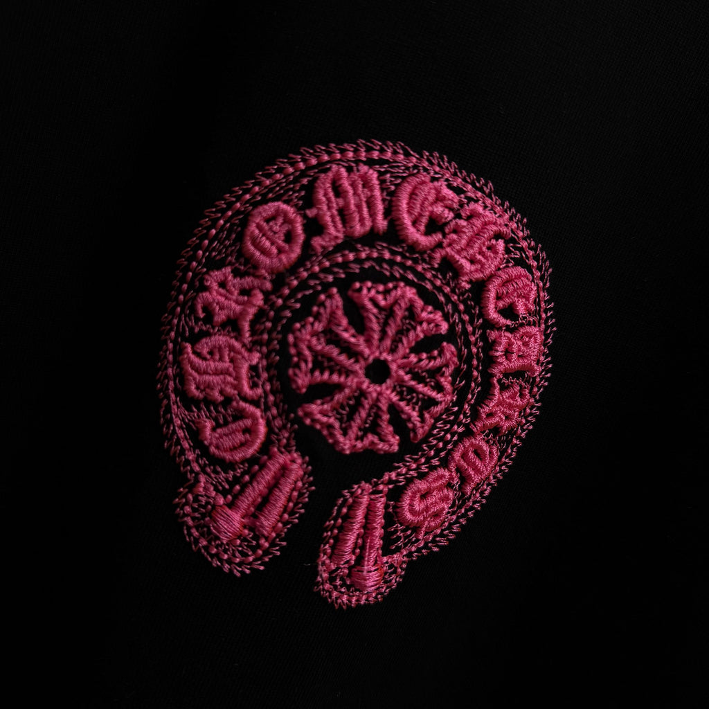 Black T-shirt with large pink embroidered circular graphic
