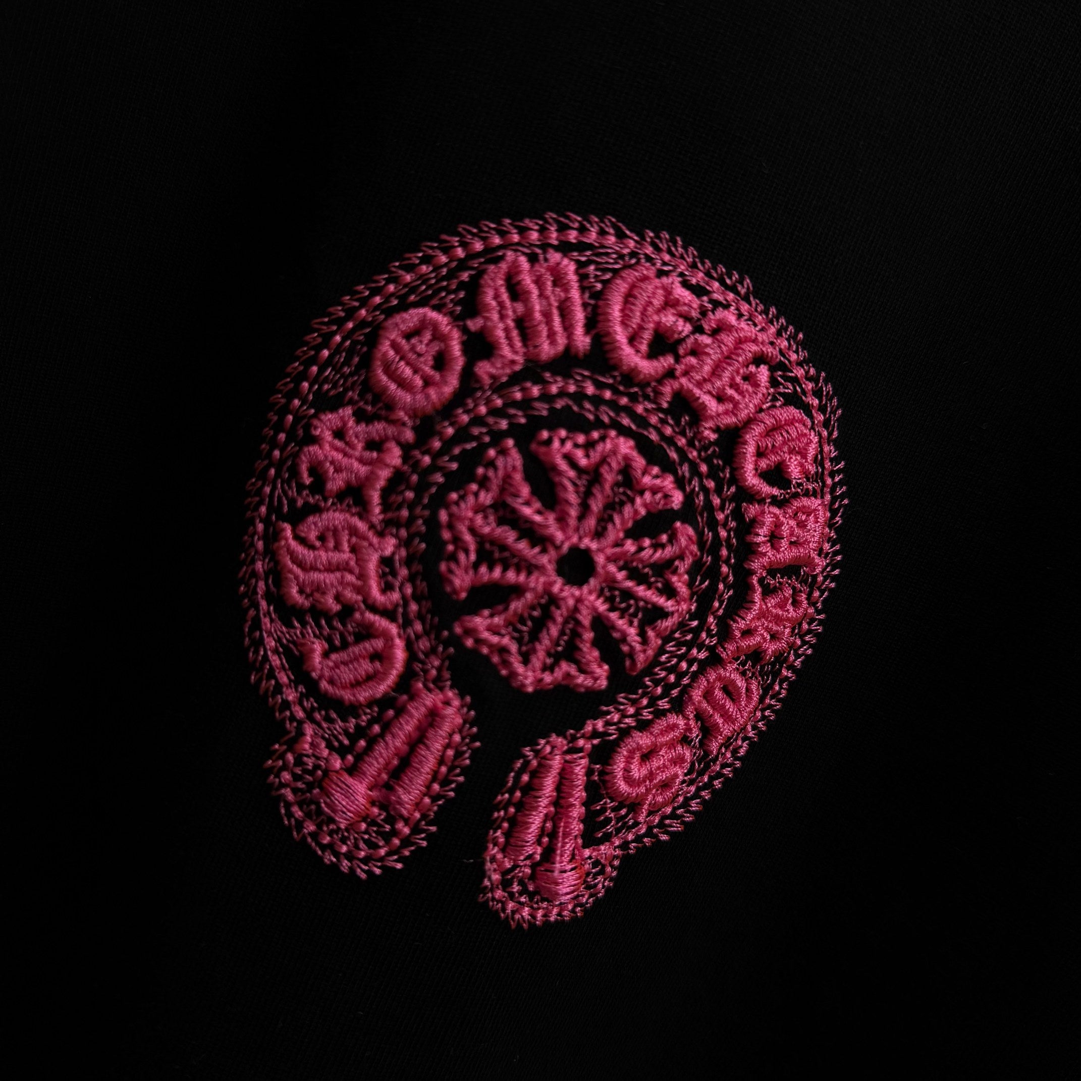 Black T-shirt with large pink embroidered circular graphic