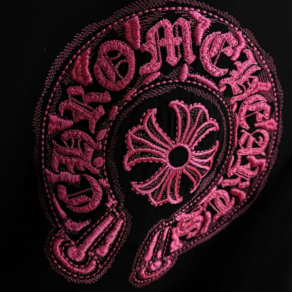 Black T-shirt with detailed pink embroidered circular emblem