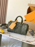 Green monogram handbag with top handles, gold hardware, and zipper closure.