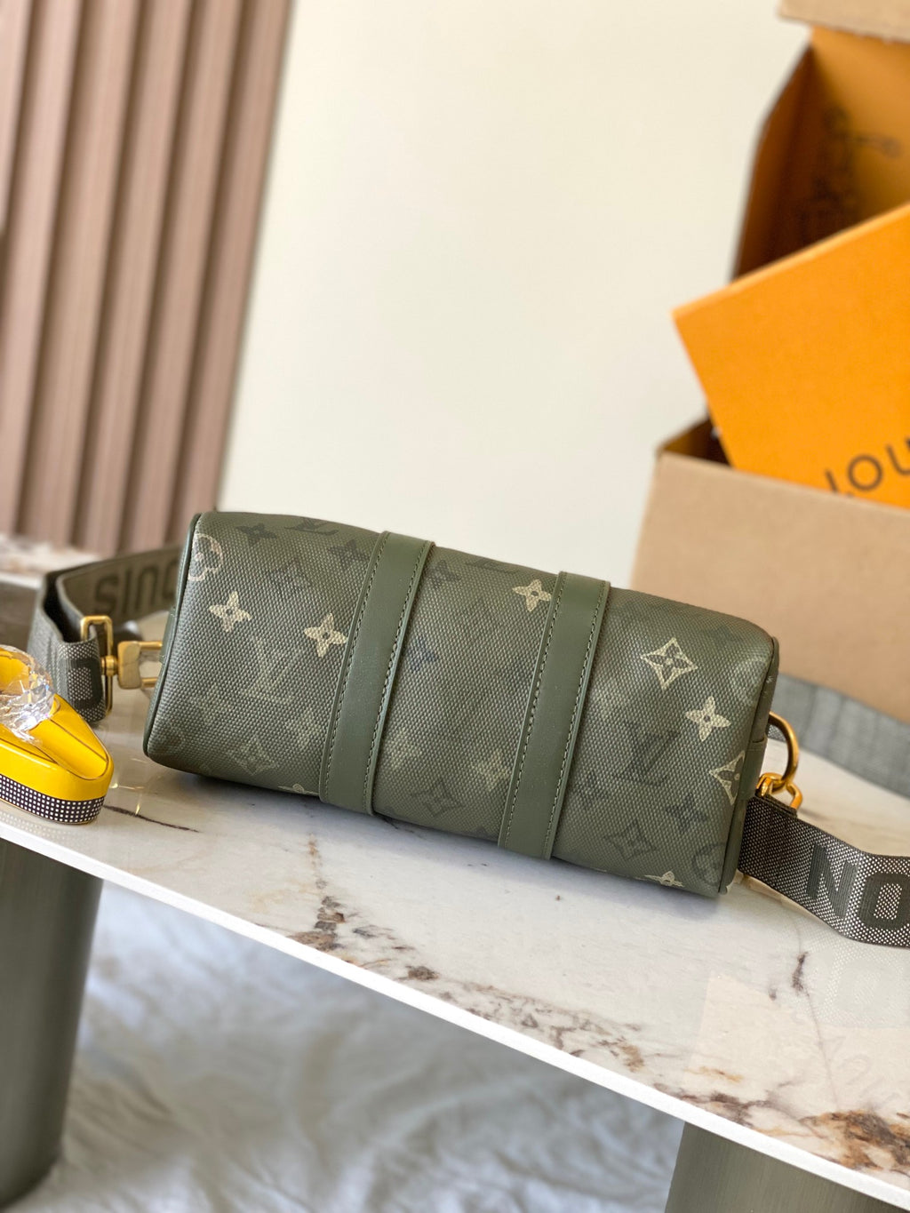 Green monogram handbag with folded front panel design and gold-tone hardware.