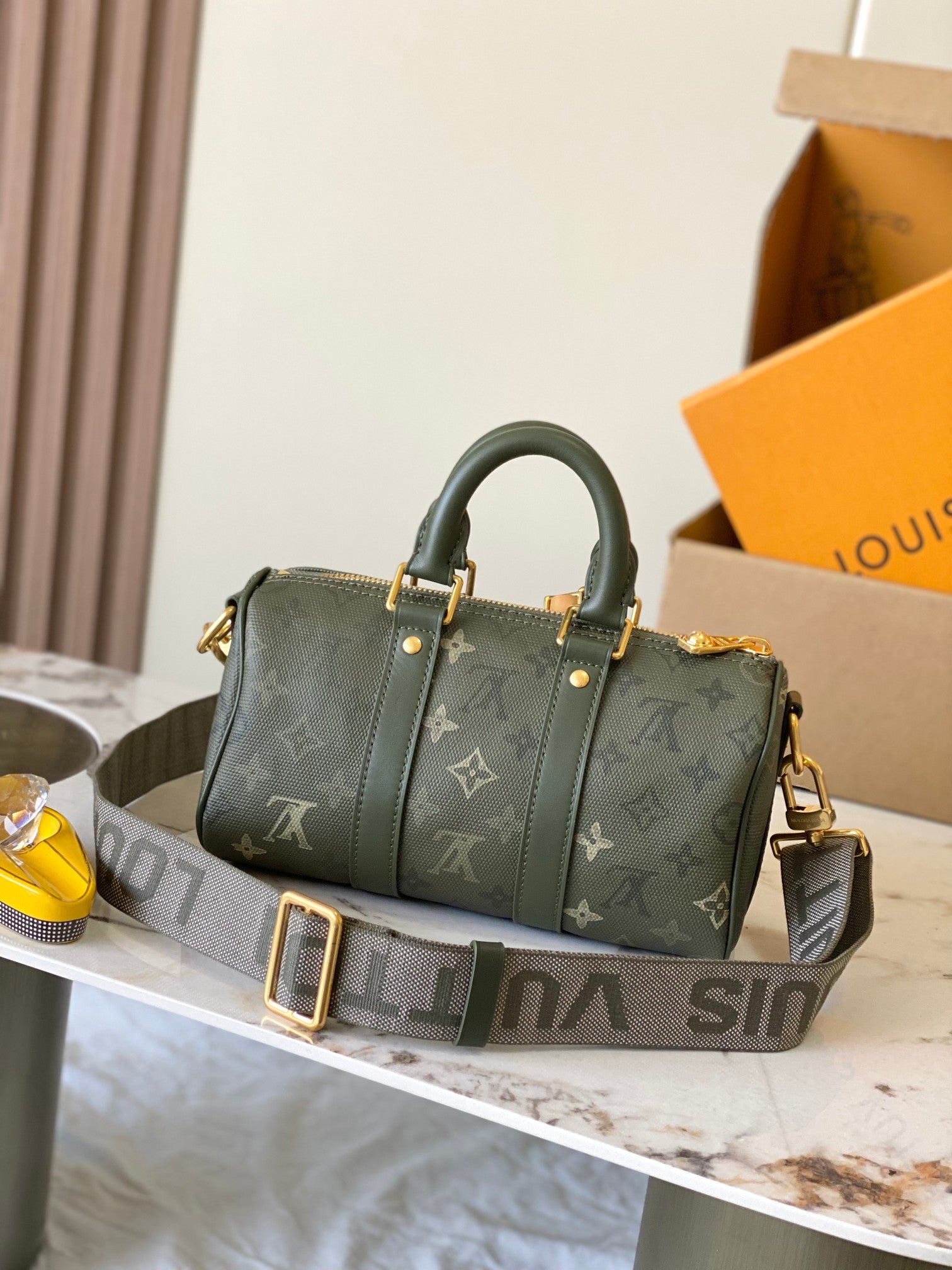 Louis Vuitton green monogram handbag with structured top handles and gold accents