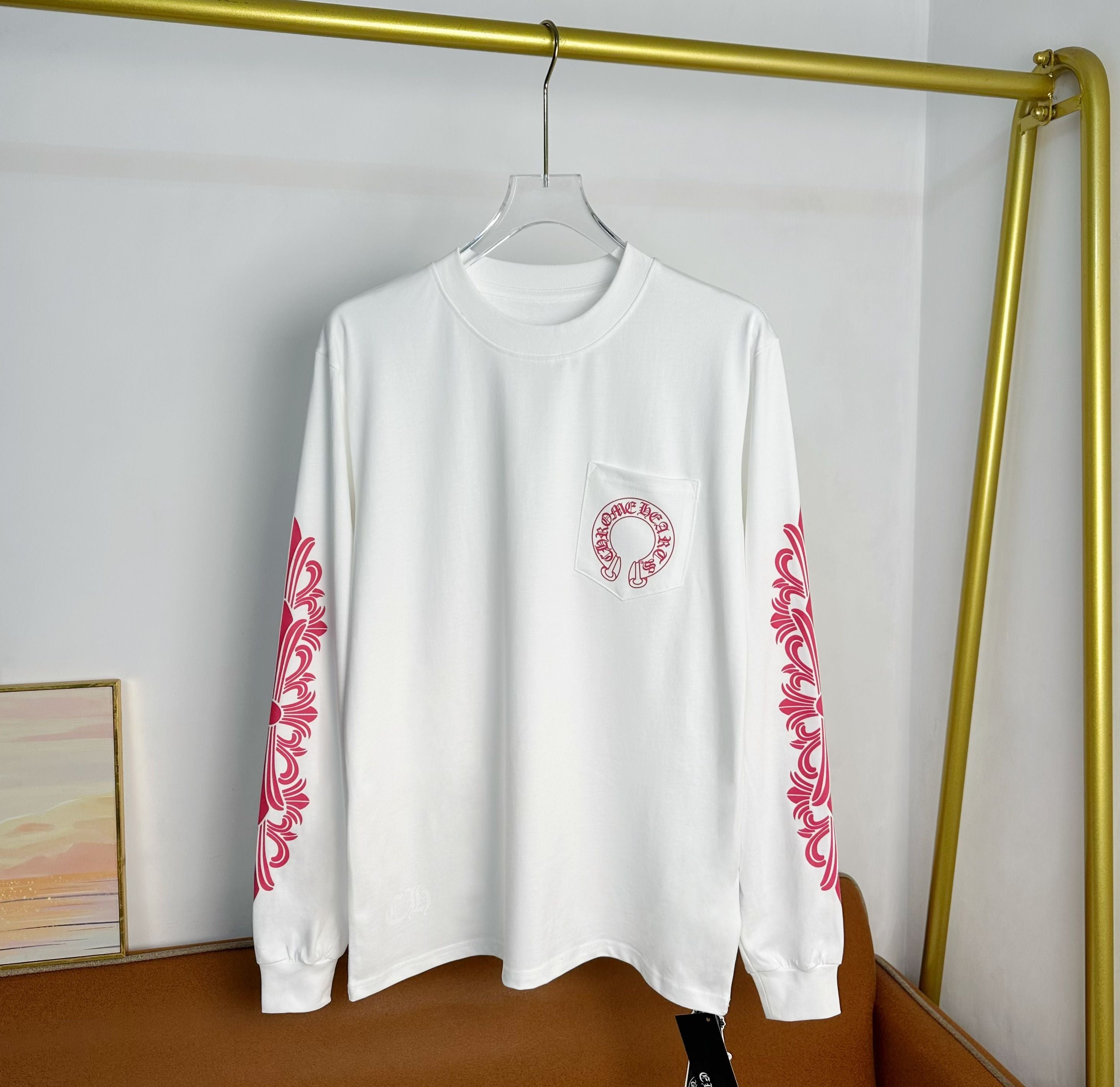 White long-sleeve T-shirt with small chest logo and red sleeve accents