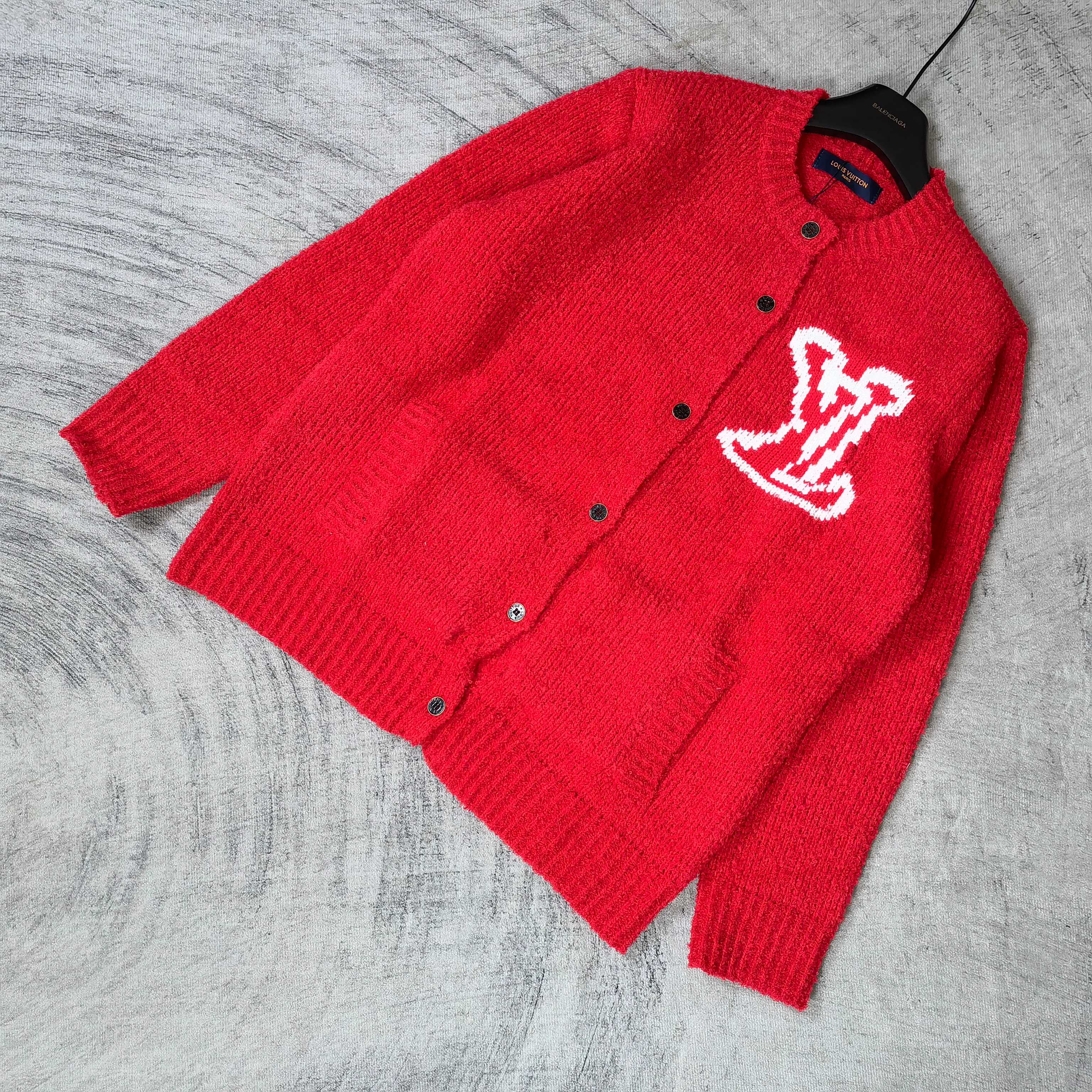 Red knit cardigan with button front and white LV monogram, laid at angle