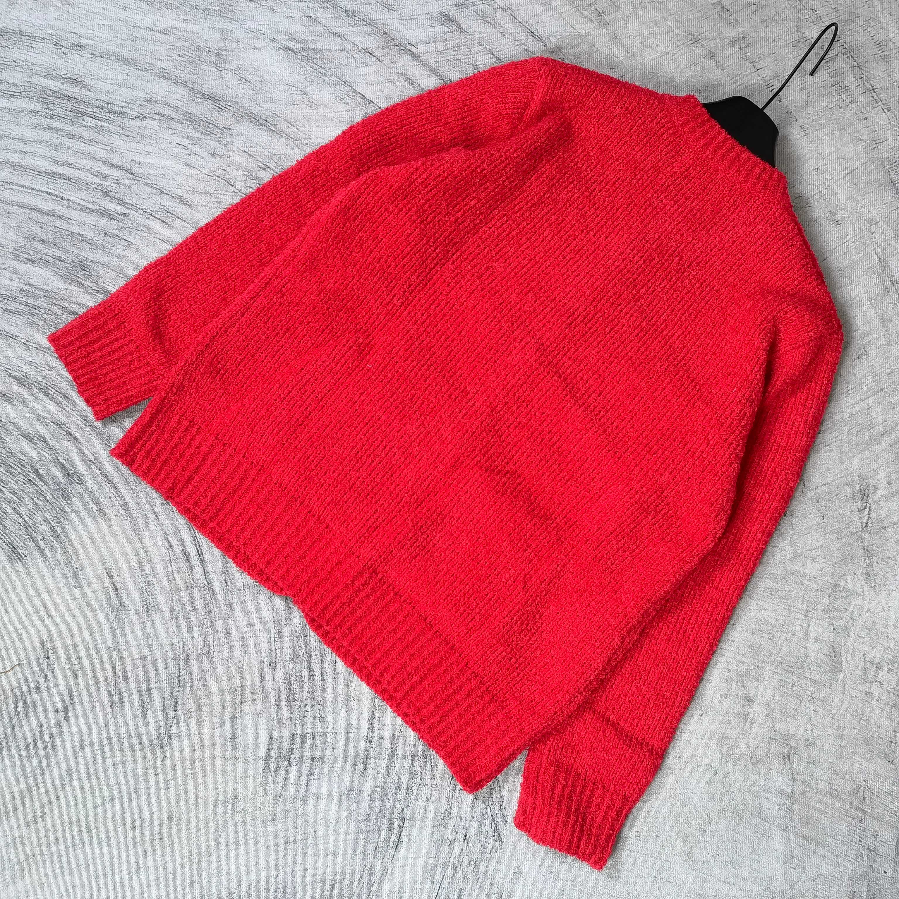 Red knit cardigan folded with crew neck and button placket visible