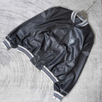 Balenciaga leather bomber jacket angled view with front zipper and striped collar trim